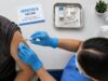 Health care worker administering a hepatitis B vaccine overhead shot