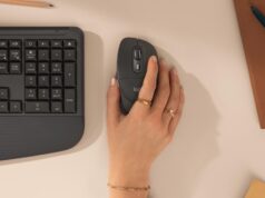A hand resting on the Logitech Signature Comfort Plus M850 L mouse next to the keyboard