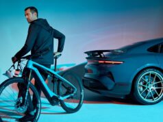 A rider on a Porsche eBike beside a Porsche Taycan Turbo GT