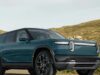 Rivian R2 electric SUV in blue parked on a coastal road