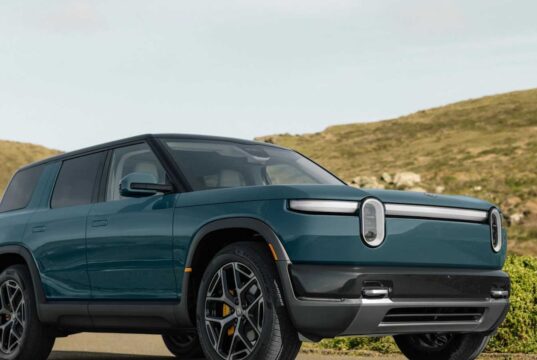Rivian R2 electric SUV in blue parked on a coastal road