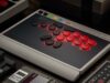 8BitDo Arcade Controller Pro leverless fight stick on a desk beside a retro console