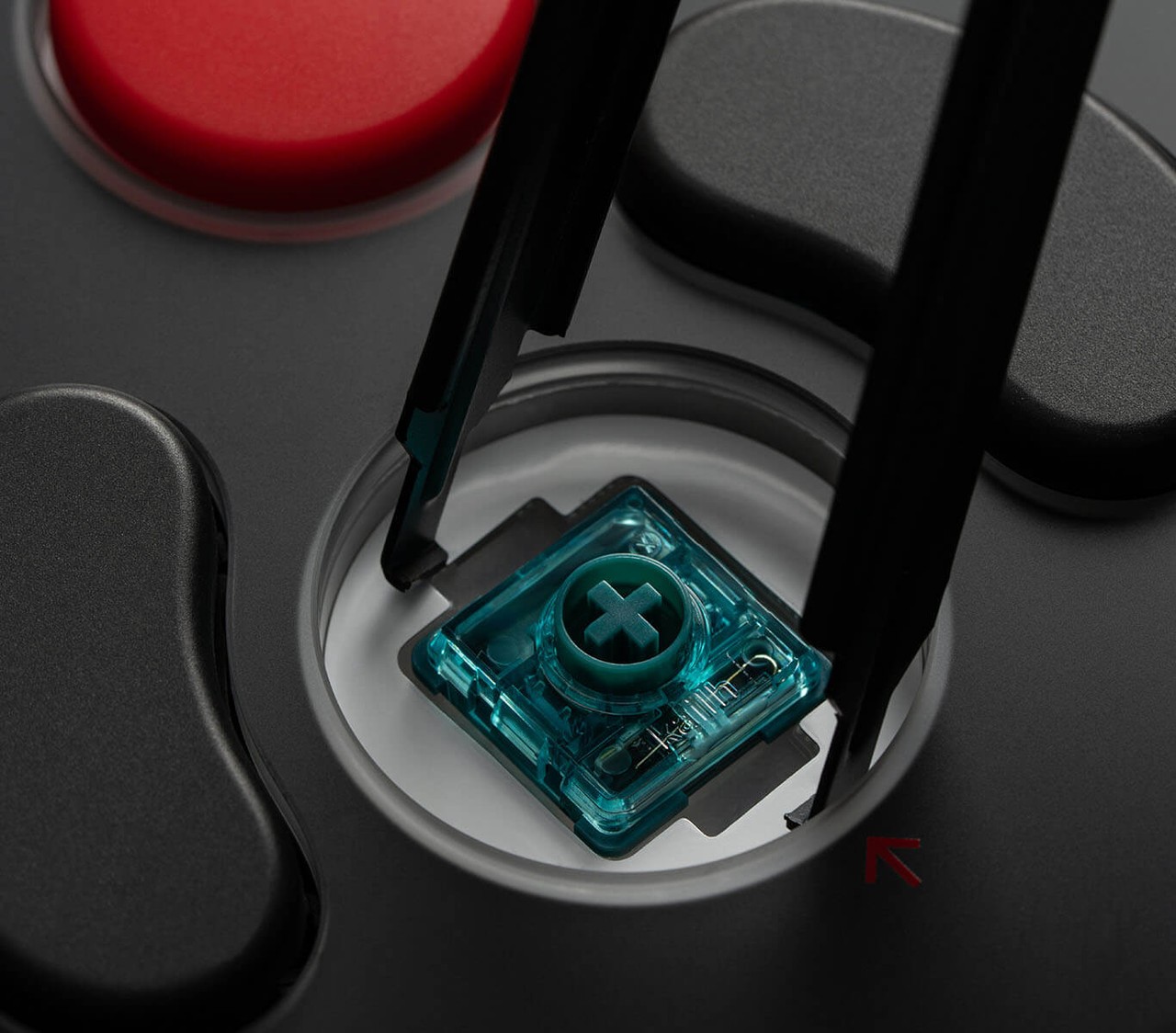 Close-up of a hot-swappable 8BitDo Core Green mechanical switch being lifted from the Arcade Controller Pro