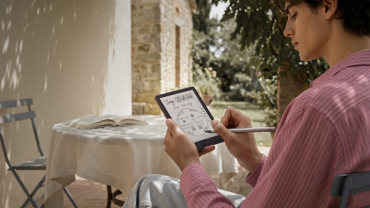 Person writing a to-do list on a Boox e-reader with the InkSense Plus stylus outdoors