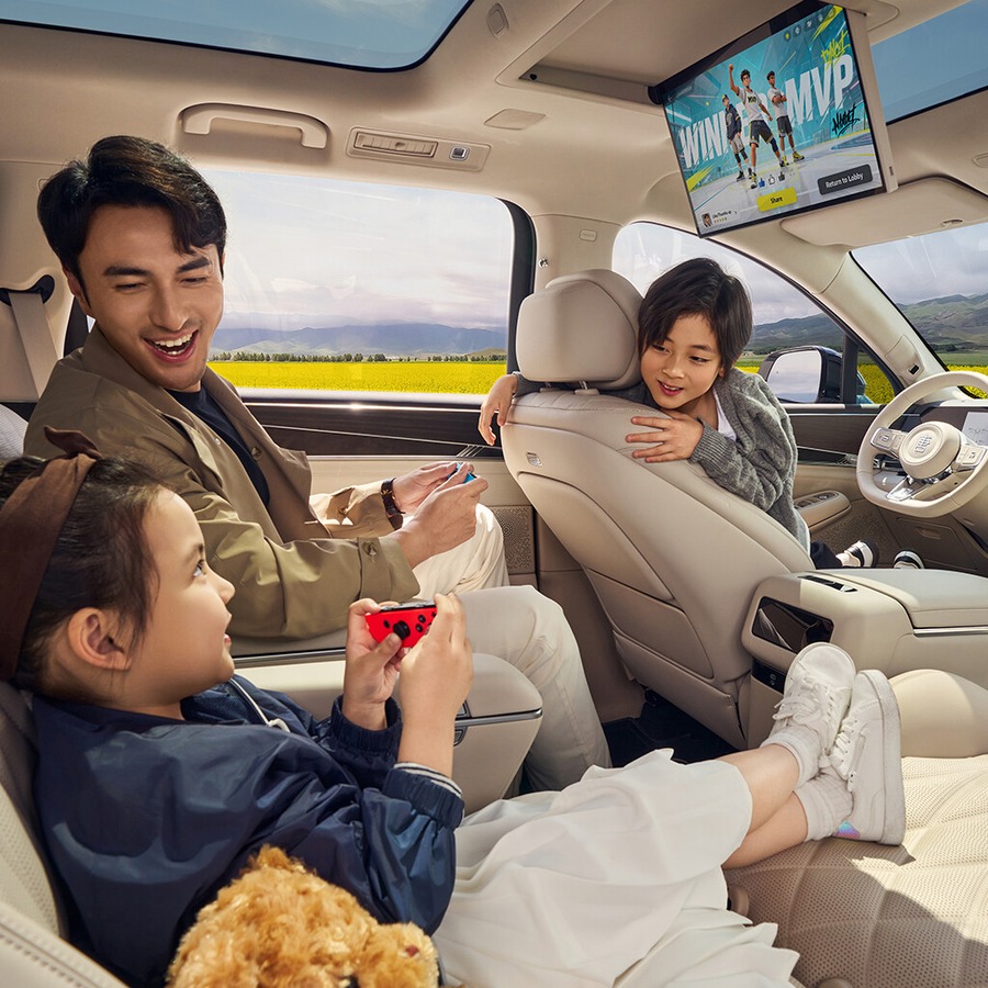 BYD Da Tang EV rear cabin showing passengers and a roof-mounted entertainment screen.