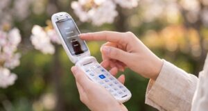 Commodore Callback 8020 flip phone open in a person's hand.