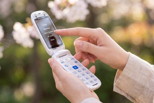 Commodore Callback 8020 flip phone open in a person's hand.