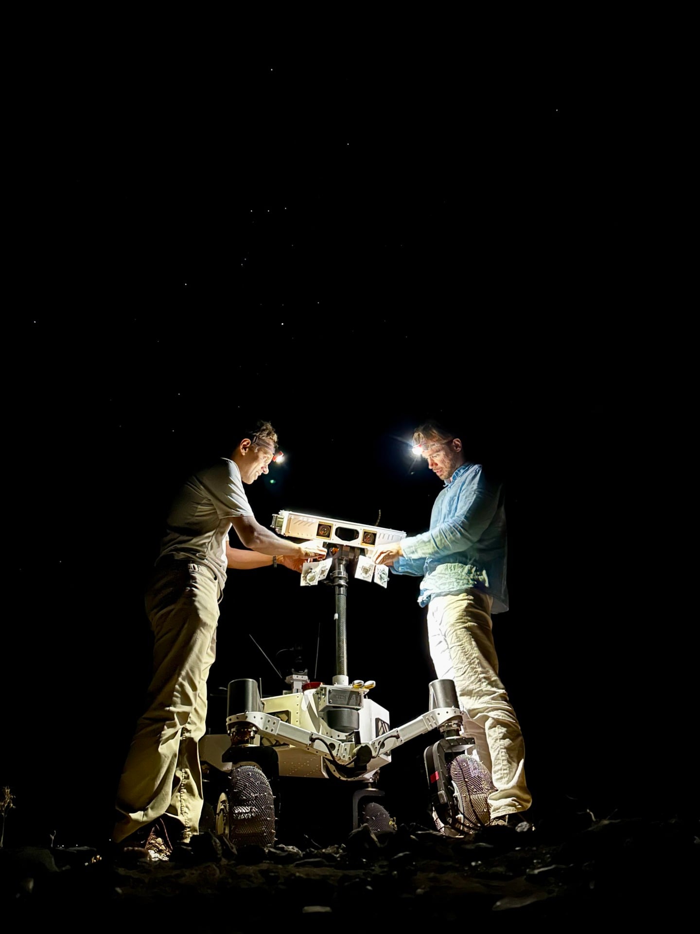 JPL engineers prepare the ERNEST rover for a pre-sunrise test in the desert.