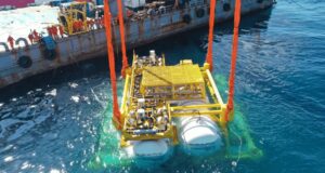 Hailanyun underwater data center module being lowered into the sea from a barge