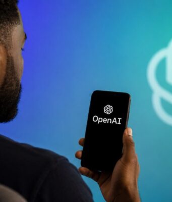 African American man holding a phone showing OpenAI branding for IPO news