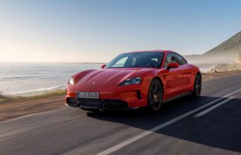 2027 Porsche Taycan Adds Fake Gears That Are Meant To Feel Real Red Porsche Taycan driving on a coastal road.