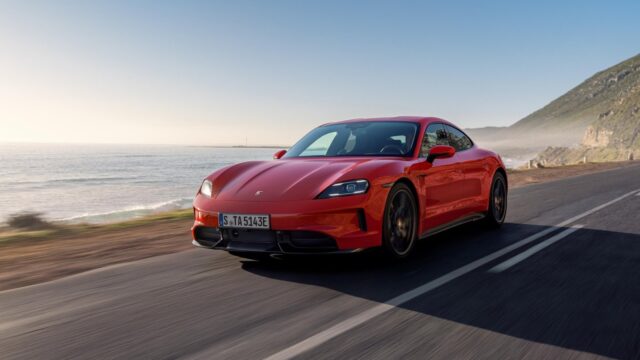 2027 Porsche Taycan exterior Red Porsche Taycan driving on a coastal road.