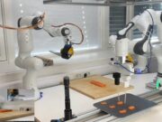 The Sashimi-Bot robot chef prepares slices of raw salmon on a cutting board.