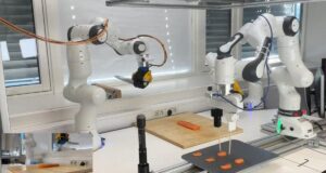 The Sashimi-Bot robot chef prepares slices of raw salmon on a cutting board.