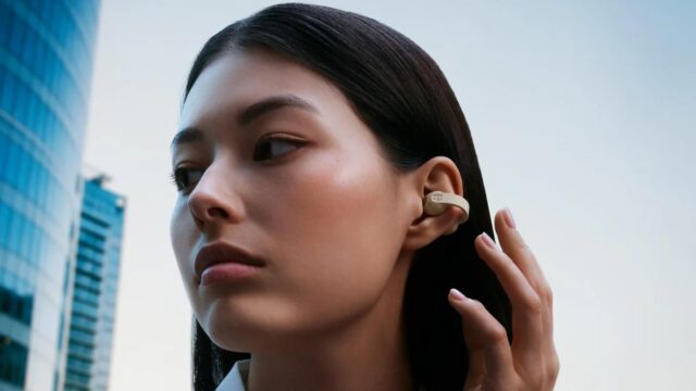 sennheiser-accentum-clip-lifestyle-16x9-crop Person wearing cream Sennheiser ACCENTUM Clip open-ear earbuds on a city street.