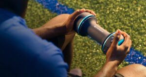 Therabody CryoTherm Palm handheld recovery device being used