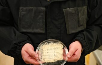 Water-harvesting jacket prototype with hydrogel panels and a fabric sample at UT Austin