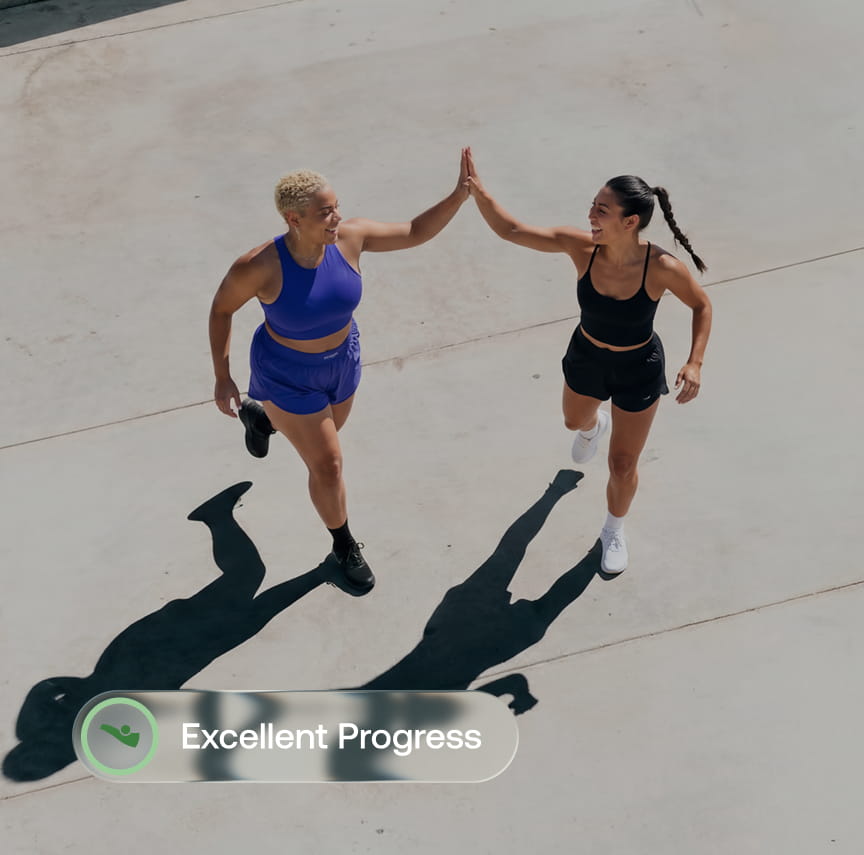 Two runners high-five during a workout, reflecting Withings BodyFit fitness coaching