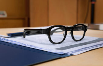 Halliday G2 AI glasses resting on documents on a desk