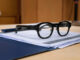 Halliday G2 AI glasses resting on documents on a desk