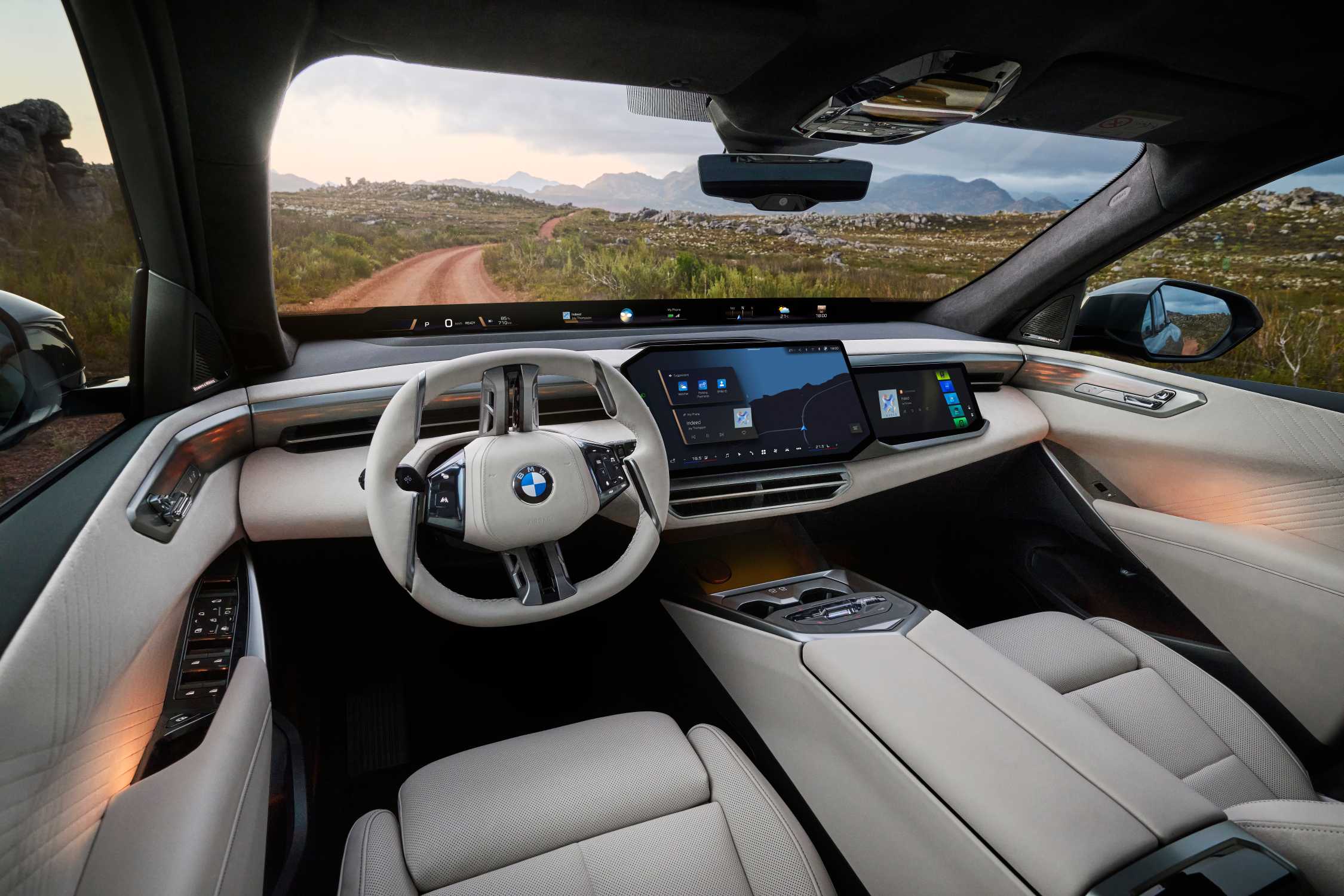 BMW iX5 interior showing Panoramic iDrive, Panoramic Vision, steering wheel, and central display in an official BMW press image
