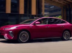BYD Seal 08 sedan in magenta finish, side profile driving through a city street