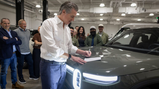 california-myfirstev-ev-rebate California EV rebate announcement with Gov. Gavin Newsom signing legislation beside a Rivian vehicle