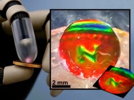 Robot finger pressing a coin next to the mechanochromic tactile sensor showing the coin's imprint as color patterns