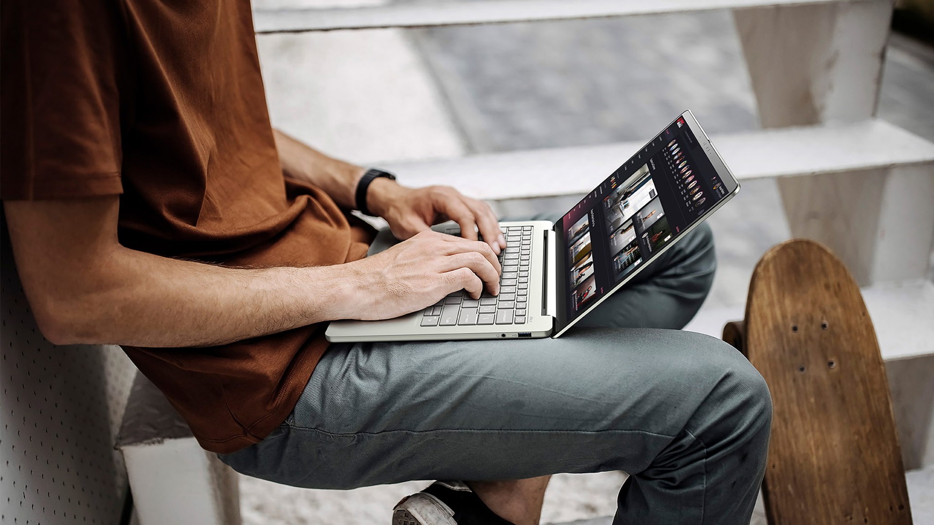 Person using a sage Acer Go Air on outdoor steps with the 14-inch screen open