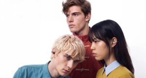 Three people wearing CMF Clip Pro open-ear earbuds in dark grey, coral, and light grey