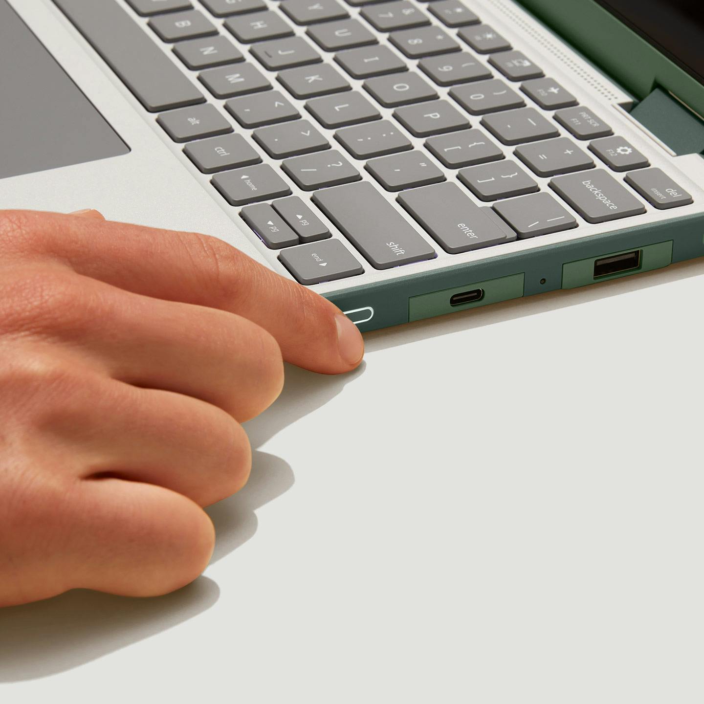 Finger pressing the side fingerprint reader on a Sage Framework Laptop 12