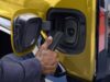 Official GM photo of a NACS charger plug at the charge port of a yellow GMC Hummer EV