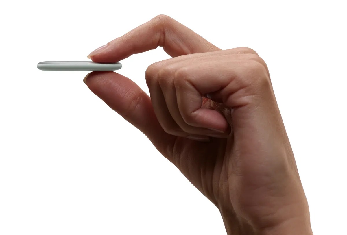 Hand holding a Google Pixel Tag between two fingers