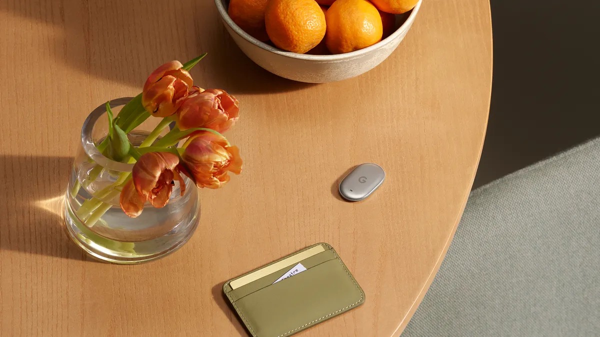 Google Pixel Tag on a wooden table next to a wallet and other everyday items