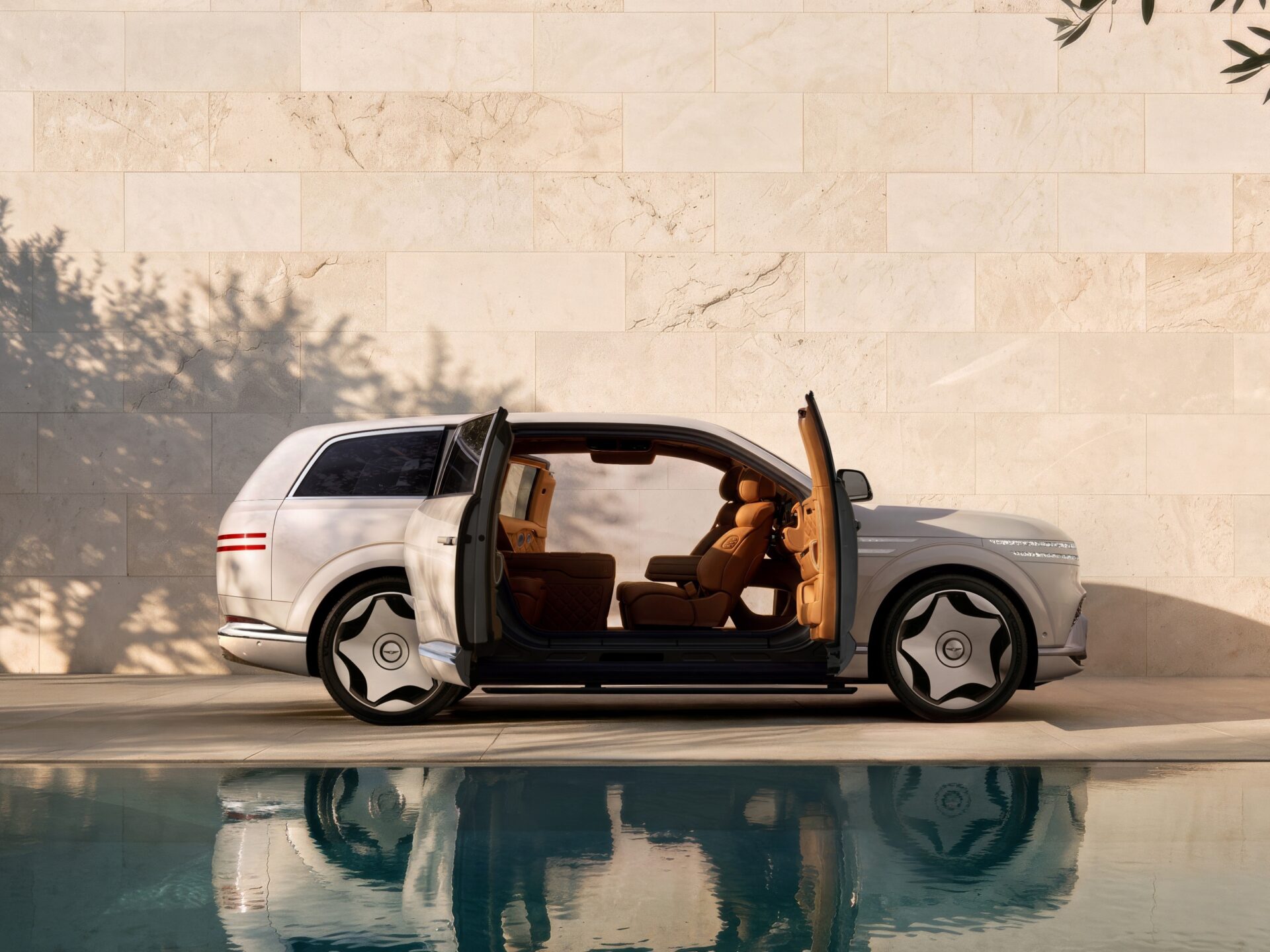 White Genesis GV90 Neolun with coach doors open beside a stone wall and pool