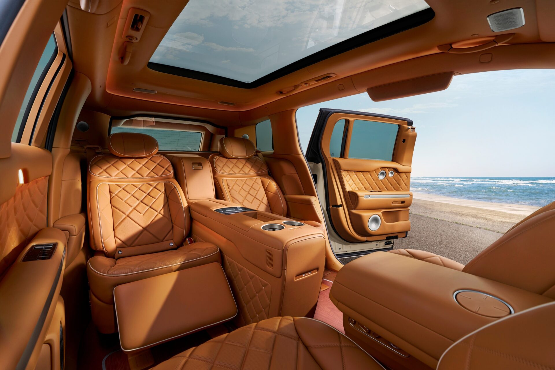 Tan quilted lounge seats and an open coach door on a Genesis GV90 Neolun Executive Suite