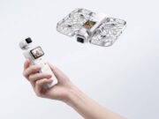 Hand holding HOVERAir VERSA pocket gimbal with flying cage-protected camera unit