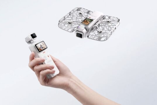 Hand holding HOVERAir VERSA pocket gimbal with flying cage-protected camera unit