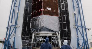 How to watch NASA’s Roman Space Telescope launch Technicians in blue clean-room suits stand before NASA's Nancy Grace Roman Space Telescope inside open Falcon Heavy fairing halves