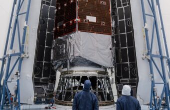 How to watch NASA’s Roman Space Telescope launch Technicians in blue clean-room suits stand before NASA's Nancy Grace Roman Space Telescope inside open Falcon Heavy fairing halves