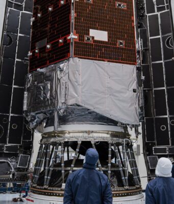 How to watch NASA’s Roman Space Telescope launch Technicians in blue clean-room suits stand before NASA's Nancy Grace Roman Space Telescope inside open Falcon Heavy fairing halves