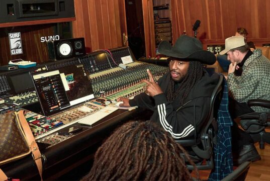 Suno audio watermarks announcement: musicians collaborating in a studio using Suno