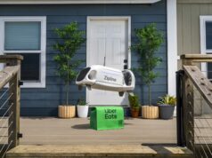 Uber Zipline Drone Delivery Aims at 1 Million a Day Zipline drone lowering an Uber Eats bag toward a front porch