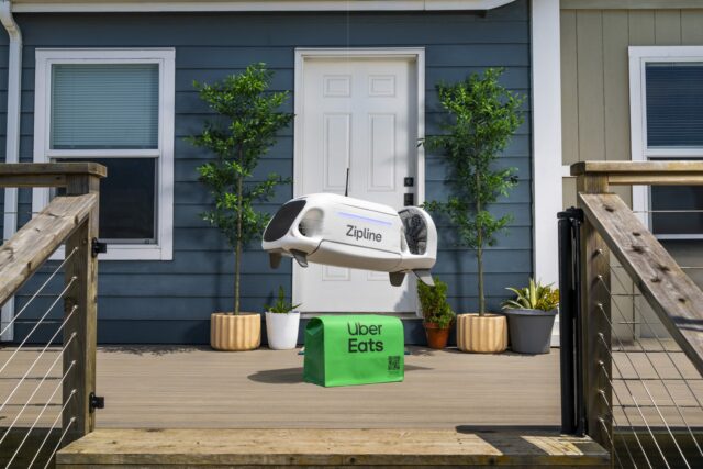 uber-zipline-drone-delivery-uber-eats Zipline drone lowering an Uber Eats bag toward a front porch