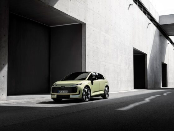 Audi A2 e-tron front three-quarter view beside a concrete building