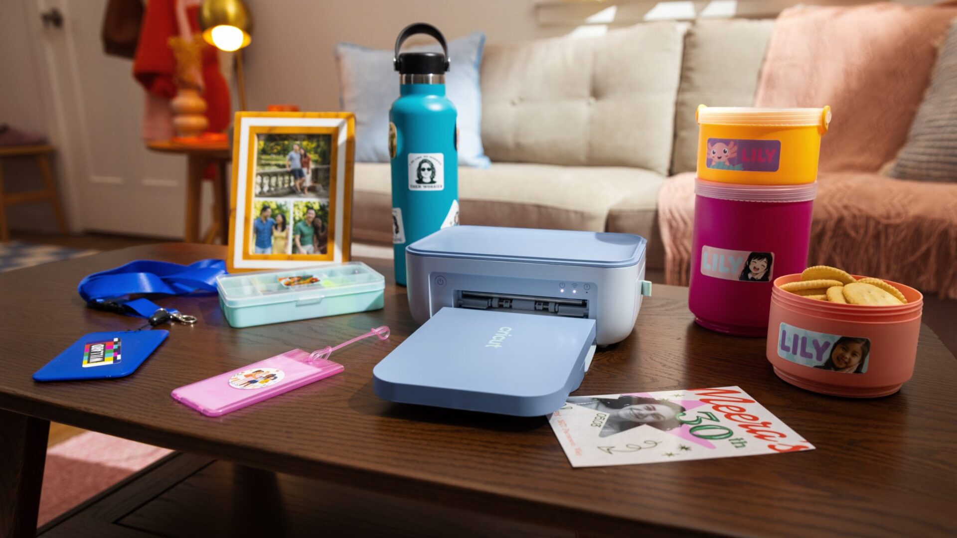 Cricut StickerPix Print on a coffee table with labeled containers, a water bottle, and photo cards