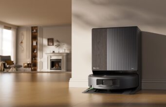 iRobot Roomba Max 875 Combo and Plus 678 Combo Launch With SealForce Vacuuming Roomba Max 875 Combo docked at its AutoWash Dock in a bright living room.