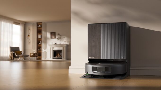 iRobot Roomba Max 875 Combo and Plus 678 Combo Launch With SealForce Vacuuming Roomba Max 875 Combo docked at its AutoWash Dock in a bright living room.