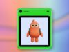 Freckle phone in green with an orange character on its screen against a coral and blue editorial background