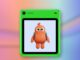 Freckle phone in green with an orange character on its screen against a coral and blue editorial background